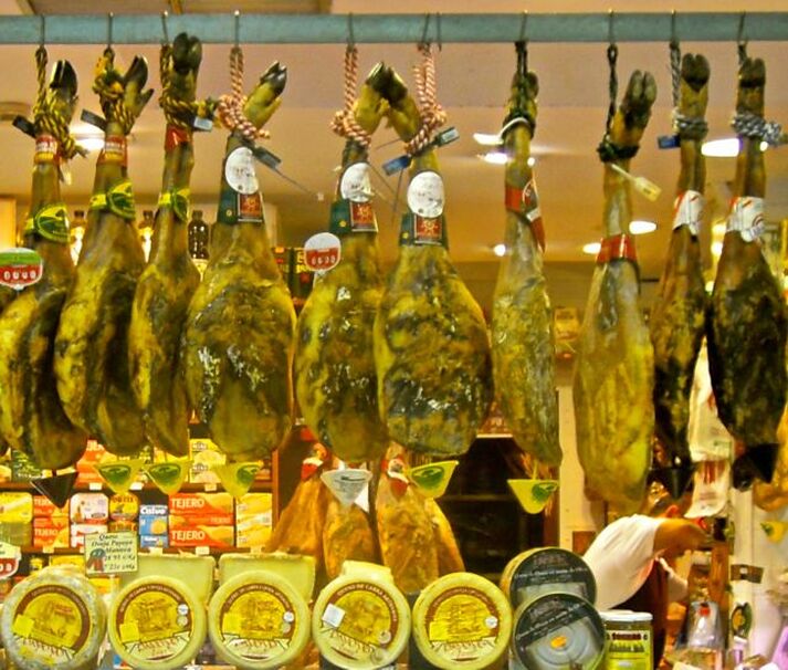 Karen McCann, Spanish ham hanging in market, Seville, Spain